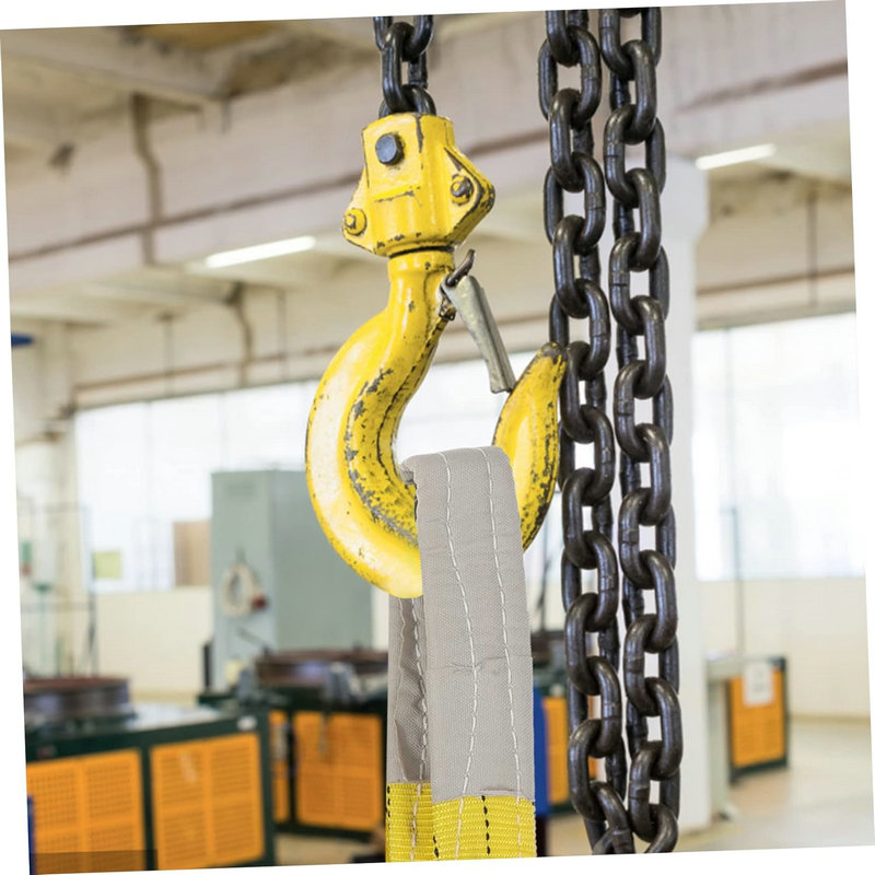 A yellow hook hoists a gray strap using a 3 Ton Webbing Sling in an industrial setting.