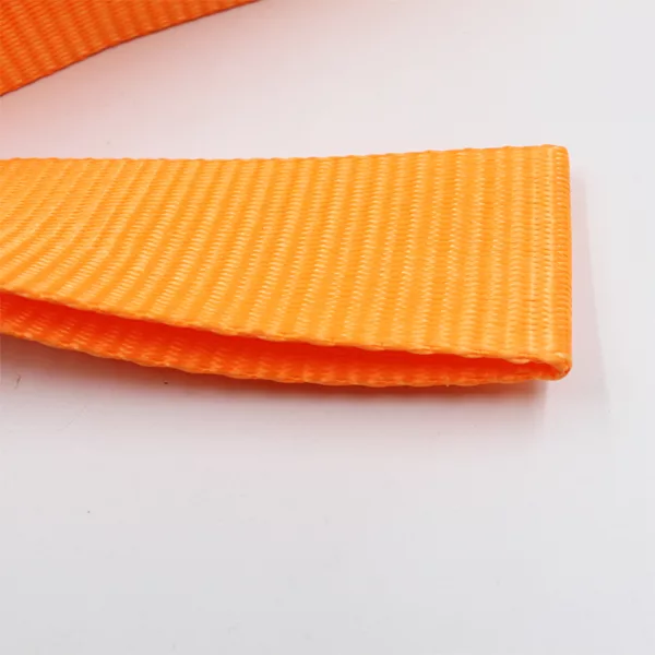 Een close-up van een oranje yogamat met textuur, gedeeltelijk opgerold tegen een witte achtergrond, die lijkt op een Endless One Way Sling.