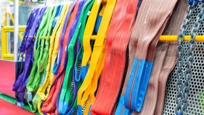 a pile of webbing slings, lifting slings, and lifting chains with hooks
