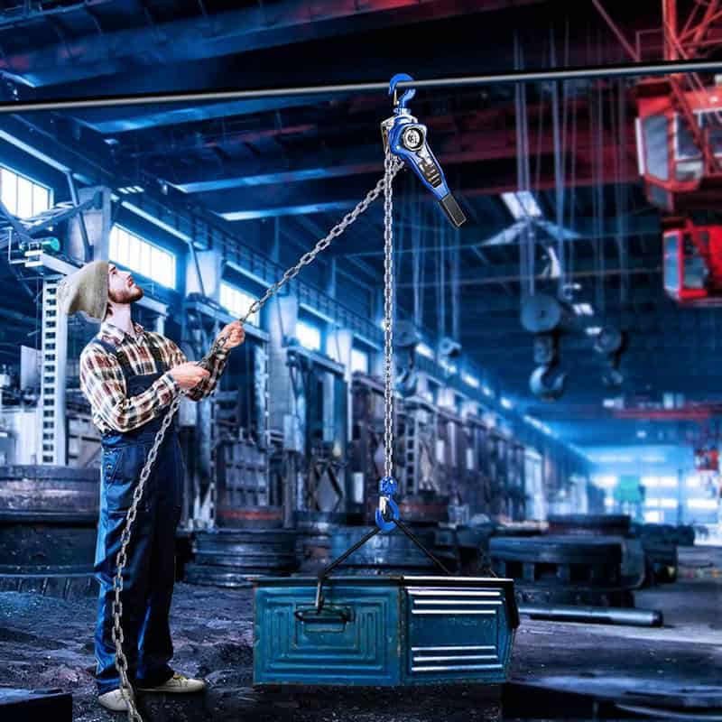 A worker using a 6-ton lever hoist to lift a metal container in an industrial factory.