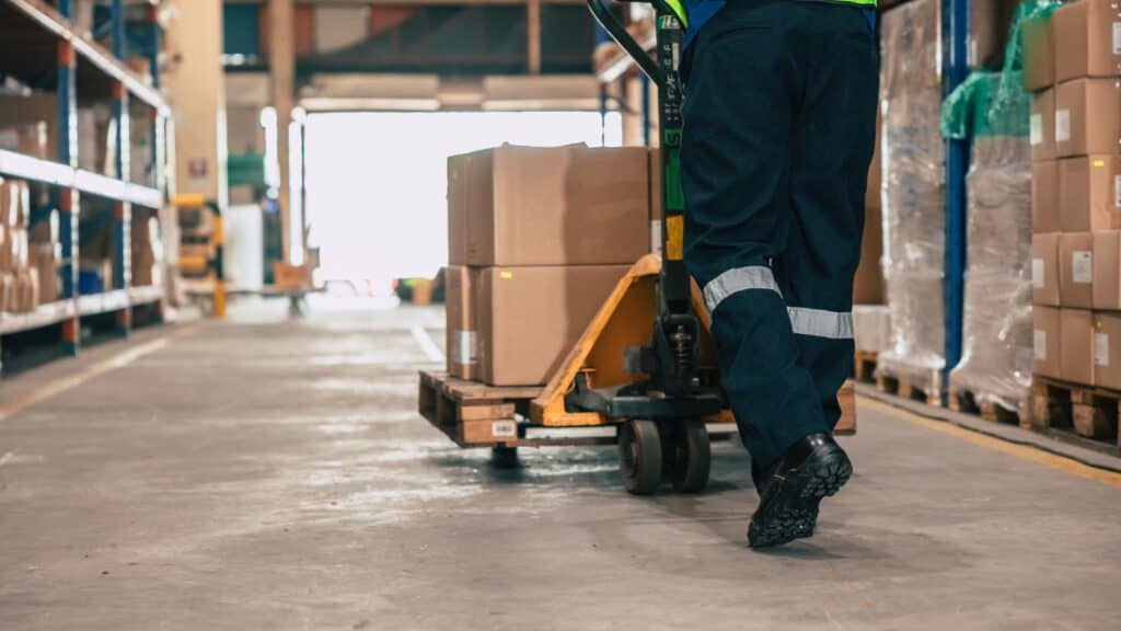 a worker using a piece of manual material handling equipment properly to avoid injury