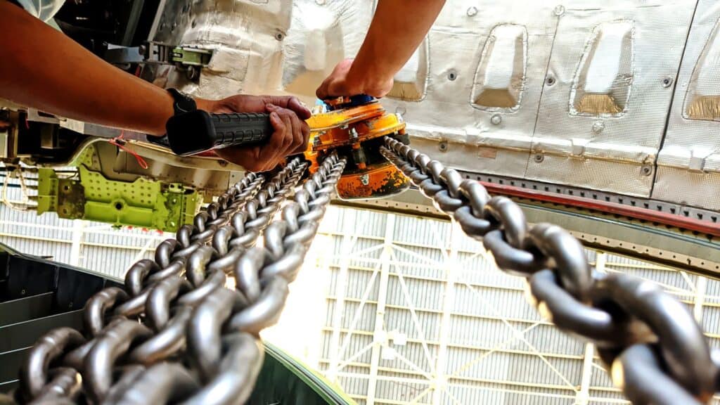 a worker using a manual chain hoist