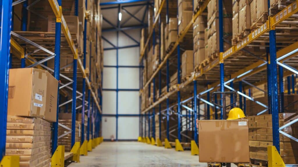 a pallet jack in a warehouse with high stack storage