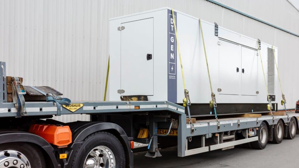 heavy generator fastened on flatbed truck for transport