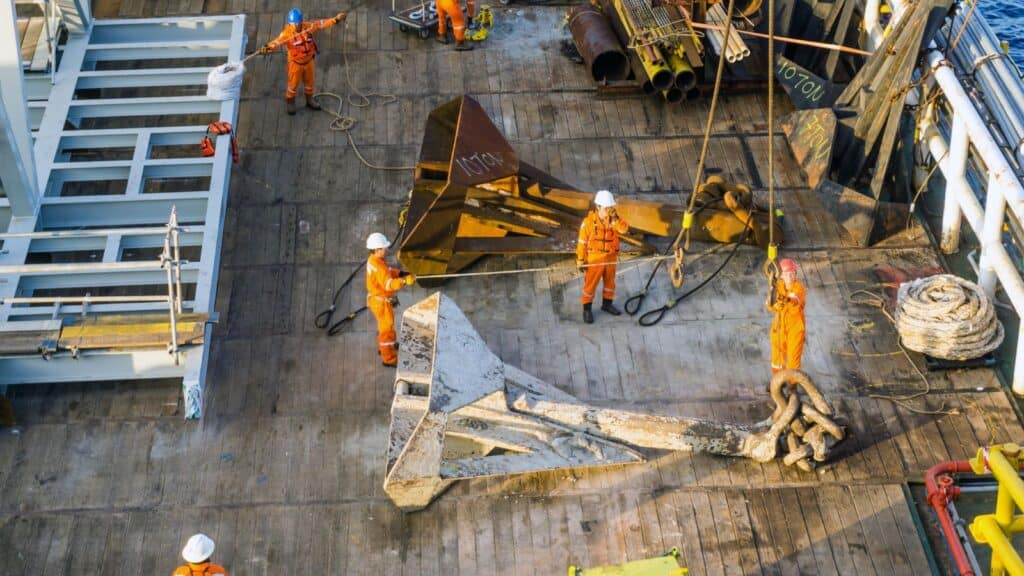 a group of workers performing maintenance on a offshore wire rope hoist